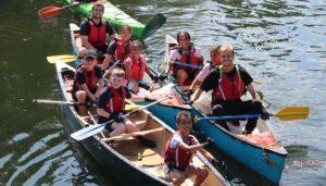 Group shot of coach and kids paddling. Used on Safeguarding Training page.