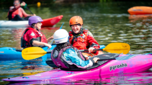Two women kayaking. Learn the ways Paddle UK supports paddlers.