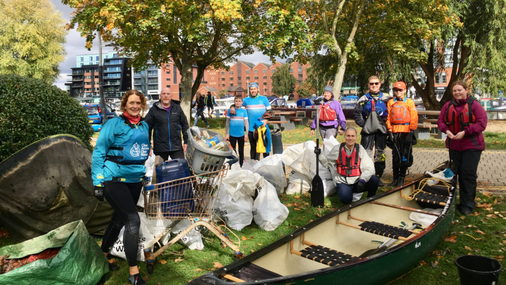 Image from the Big Paddle Clean Up with paddlers standing next to bag of collected rubbish. Used on event toolkit Environment page.