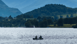 Ullswater with two people paddling a canoe. Used on safeguarding policies page.
