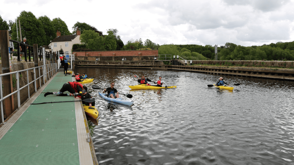 Paddlers in kayaks waiting for an event to start.