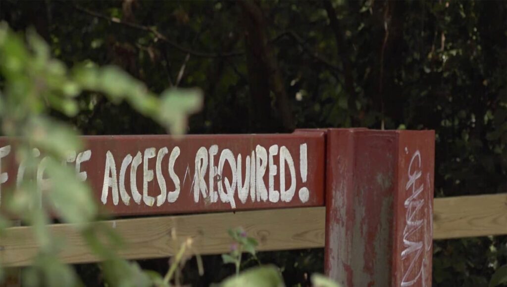 Gate displaying warning in capitals: Access Required. Clear Access, Clear Waters.