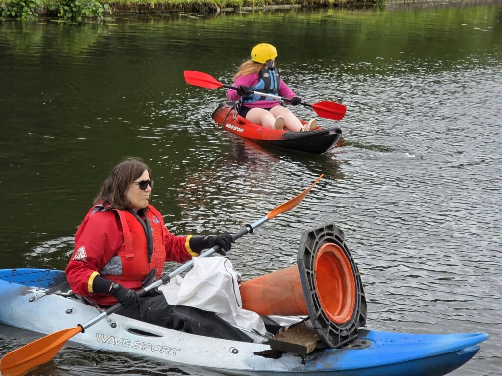 Paddlers with boats full of junk 
