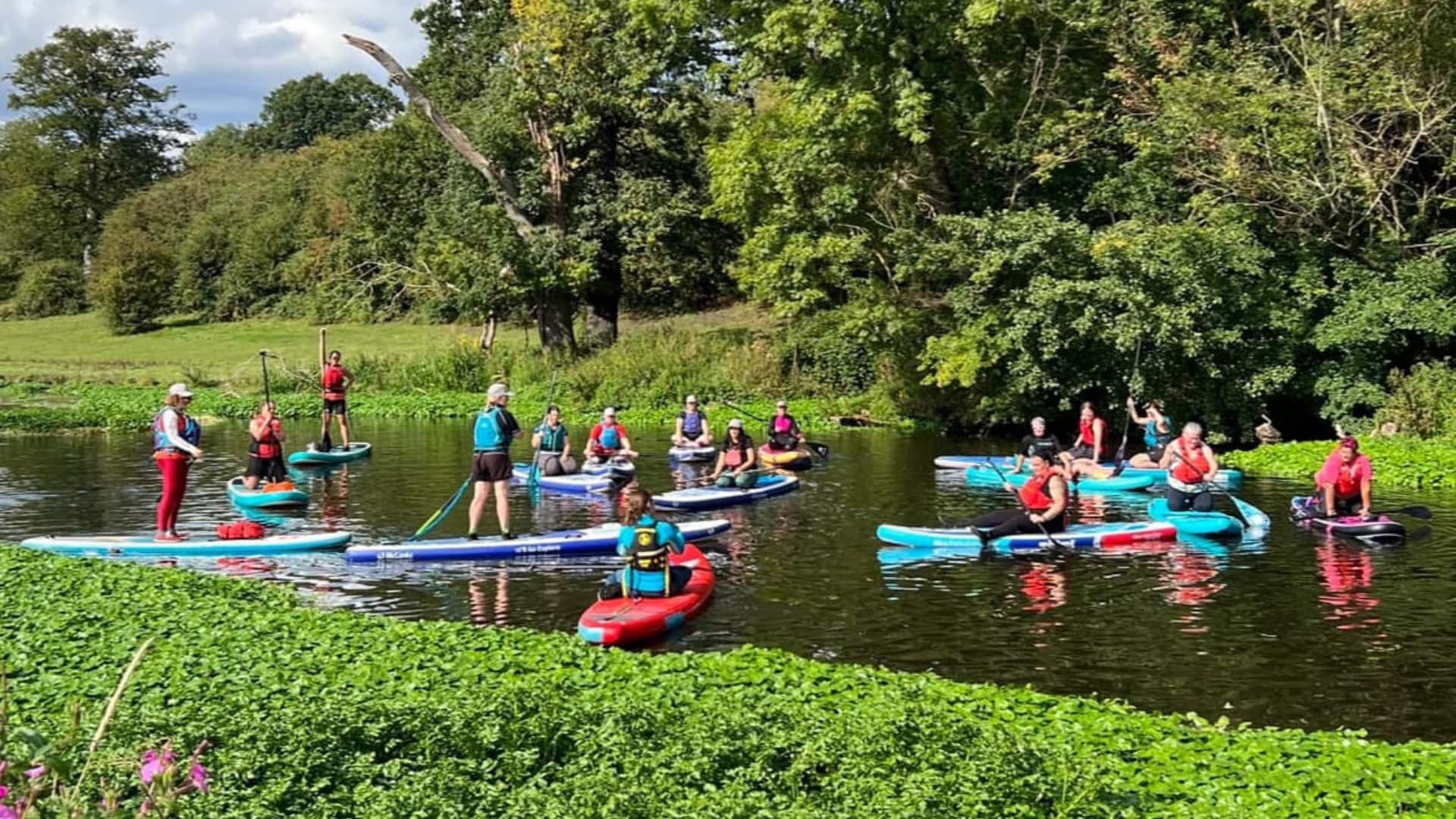 Group of women paddling on kayaks and stand up paddleboards at the #ShePaddles East Midlands event at Broadway's Meadow.