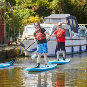 Three people paddleboarding. Become a member today.