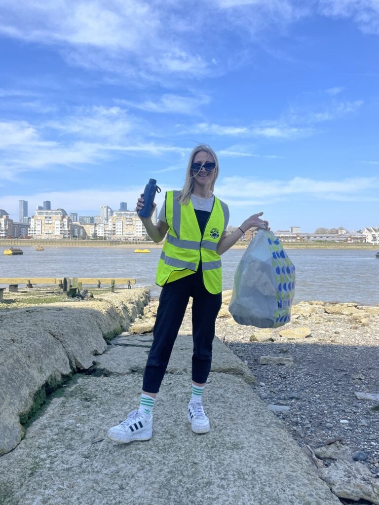 Flora by the Thames with a bag of rubbish