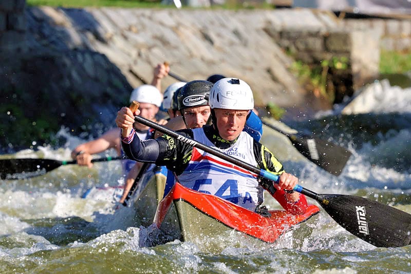 Three C2 boats in a line, paddling through whitewater.