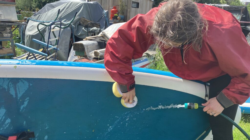 Person cleaning down a boat